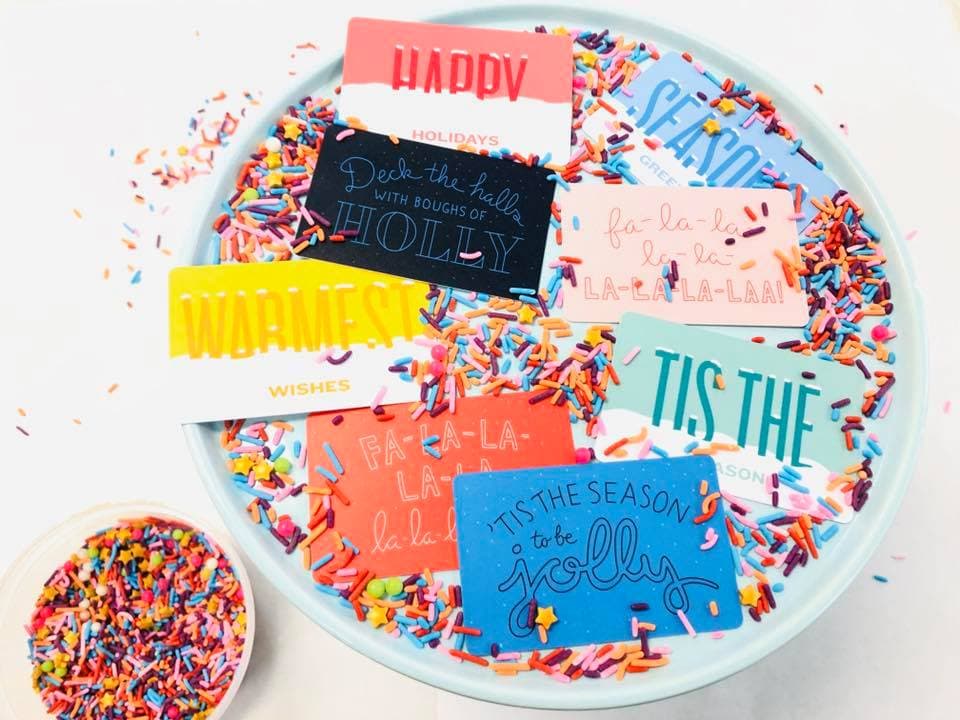Colorful Jubilee's Studio gift cards on a plate of rainbow sprinkles