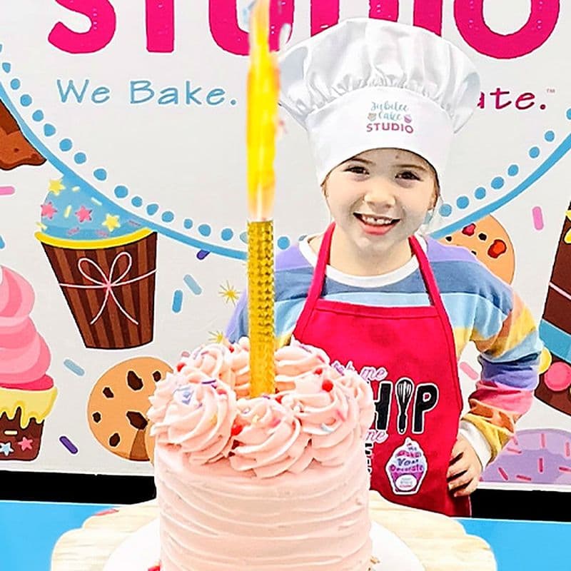 Girl behind the pink cake she decorated