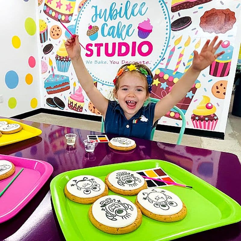 Excited girl at a party table of bright trays