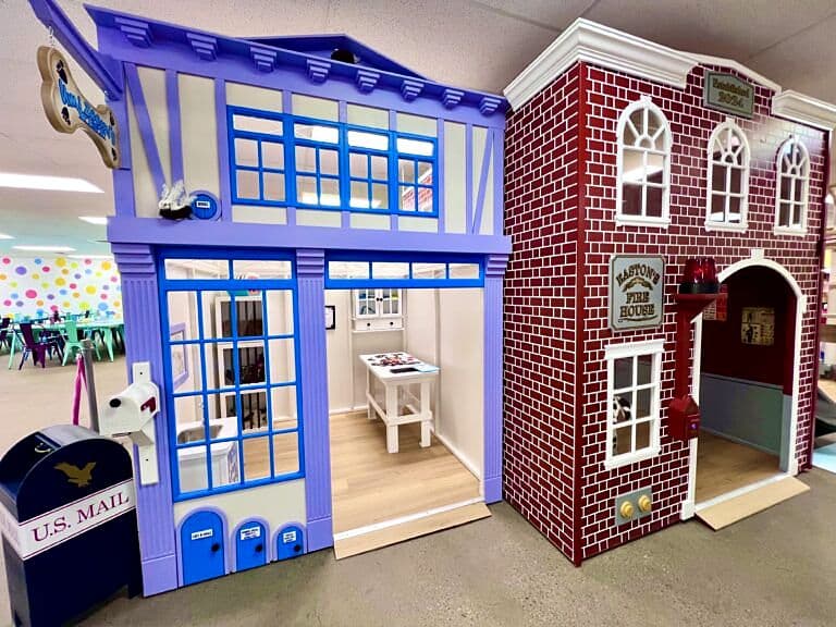 Lavender cottage and red-brick firehouse playhouses with a toy mailbox