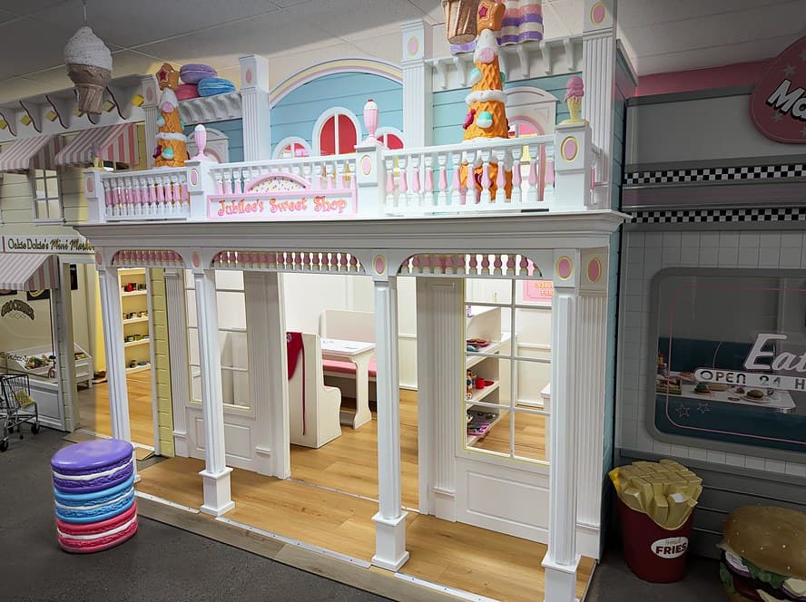 Jubilee's Sweet Shop and Okie Dokie's Mini Market playhouses with pastel awnings