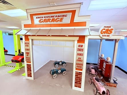 Knox Redline Racing Garage with vintage pedal cars inside and pink pedal cars at the gas pumps