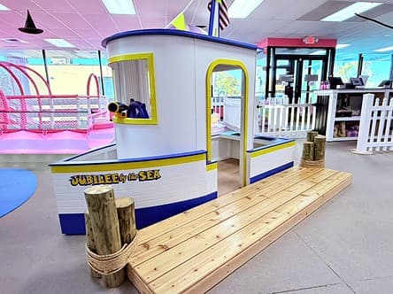 The Jubilee by the Sea tug boat with a telescope in the wheelhouse and a wooden dock